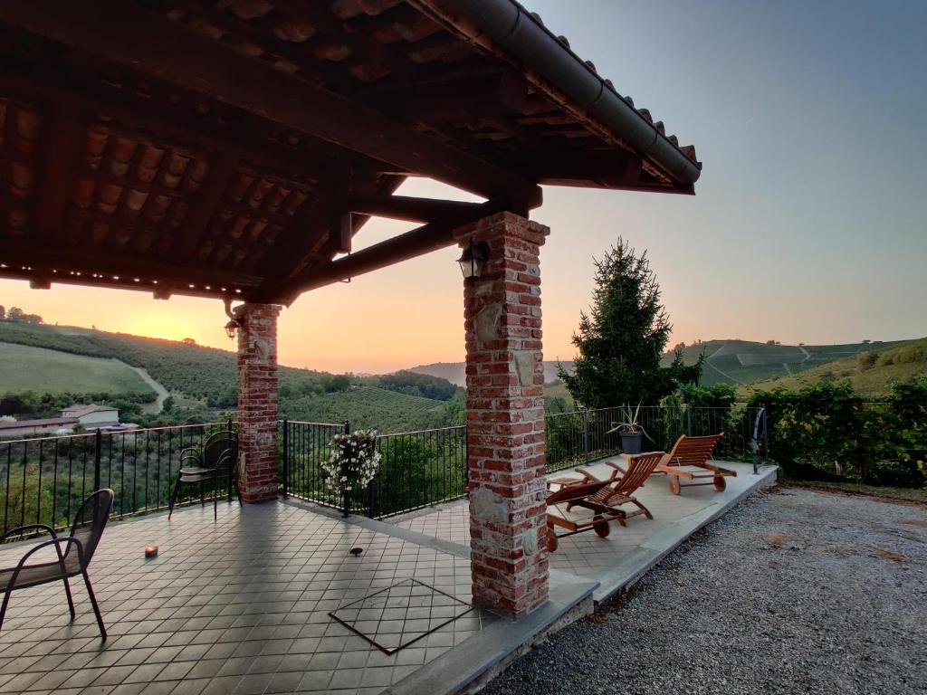 巴巴莱斯科Agriturismo Rio Sordo的一个带椅子的庭院和一个美景屋顶