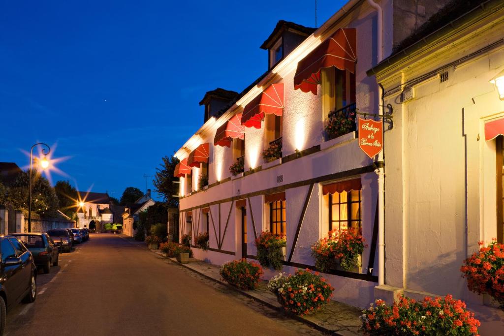 Saint-Jean-aux-Bois奥博热拉邦内伊德酒店的镇上的街道,晚上有楼