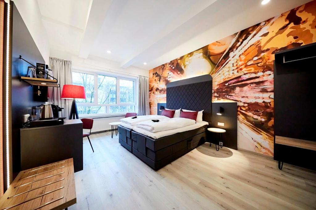 洪堡SMARTY Hotel Euler Homburg, Saar - KONTAKTLOSER SELF CHECK-IN的卧室配有一张床,墙上挂有绘画作品