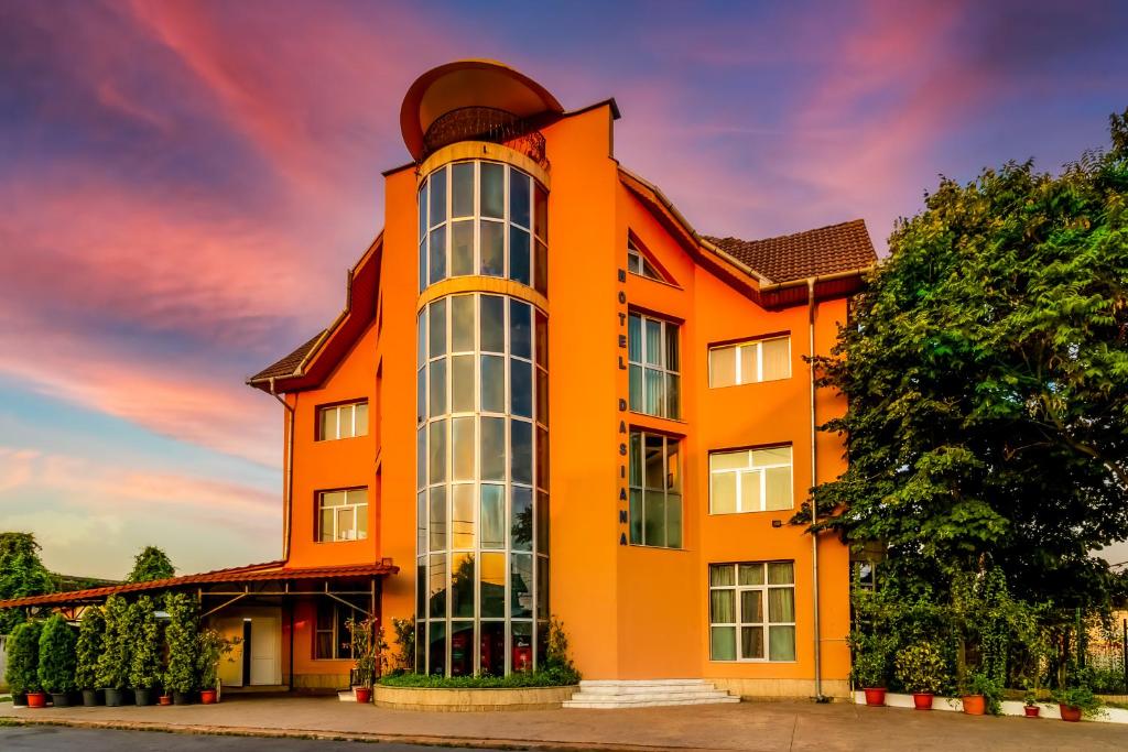 塔古玖Motel Dasiana的橙色的建筑,设有大窗户