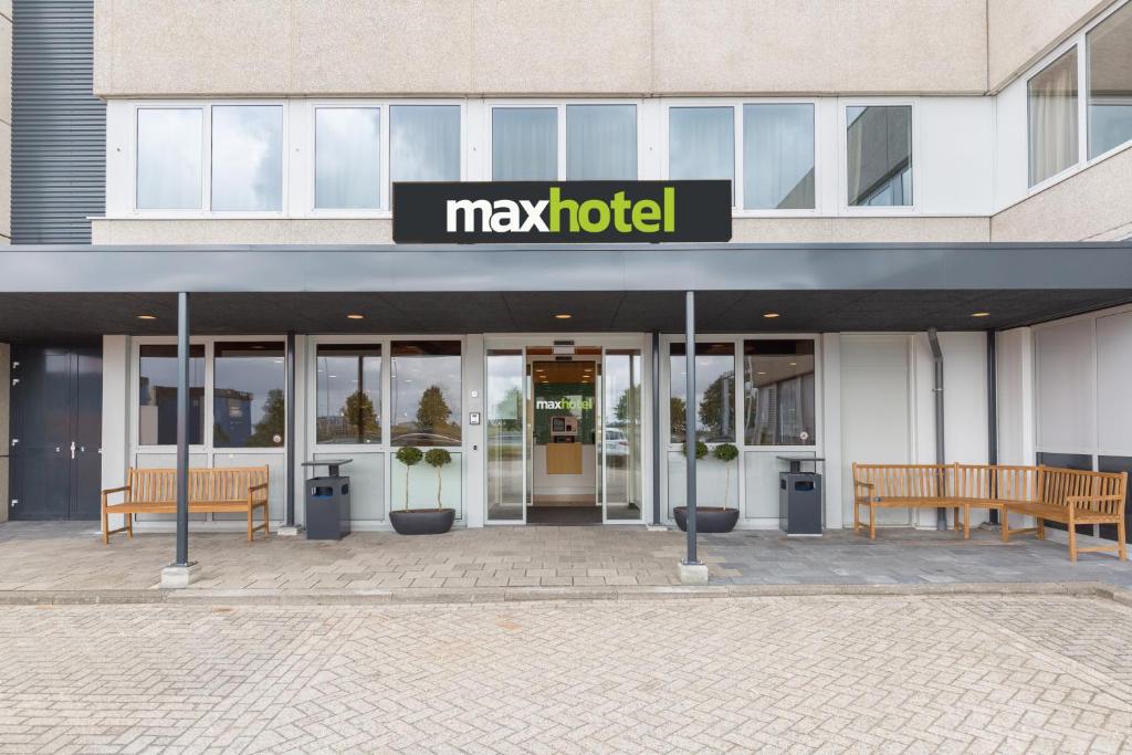 霍夫多普Maxhotel Amsterdam Airport Schiphol的一座可能的酒店大楼前面设有两个长椅