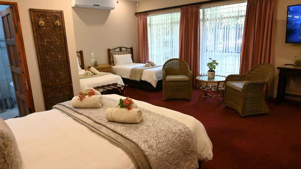 米德尔堡LUXURY FAMILY EN-SUITE ROOM @ 4 STAR GUEST HOUSE的酒店客房设有两张床和电视。