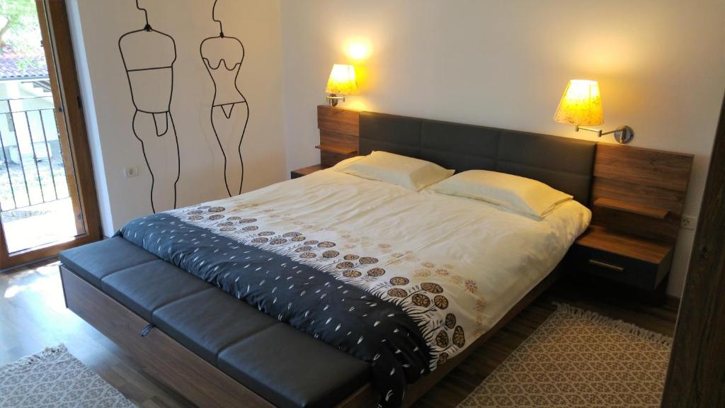 PobegiKmetija Jogan, Wines & Apartments的一间卧室配有一张带黑色皮革床头板的床