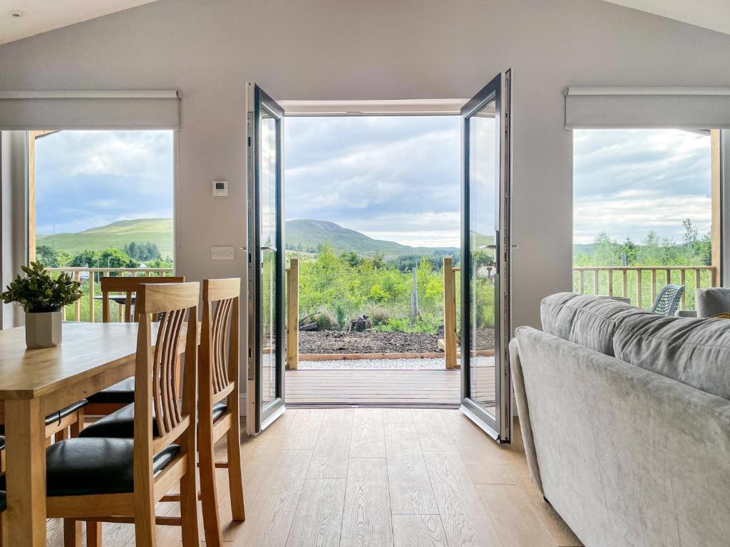 布罗德福德Broadford Lodges Skye的客厅配有桌子、沙发和玻璃门。