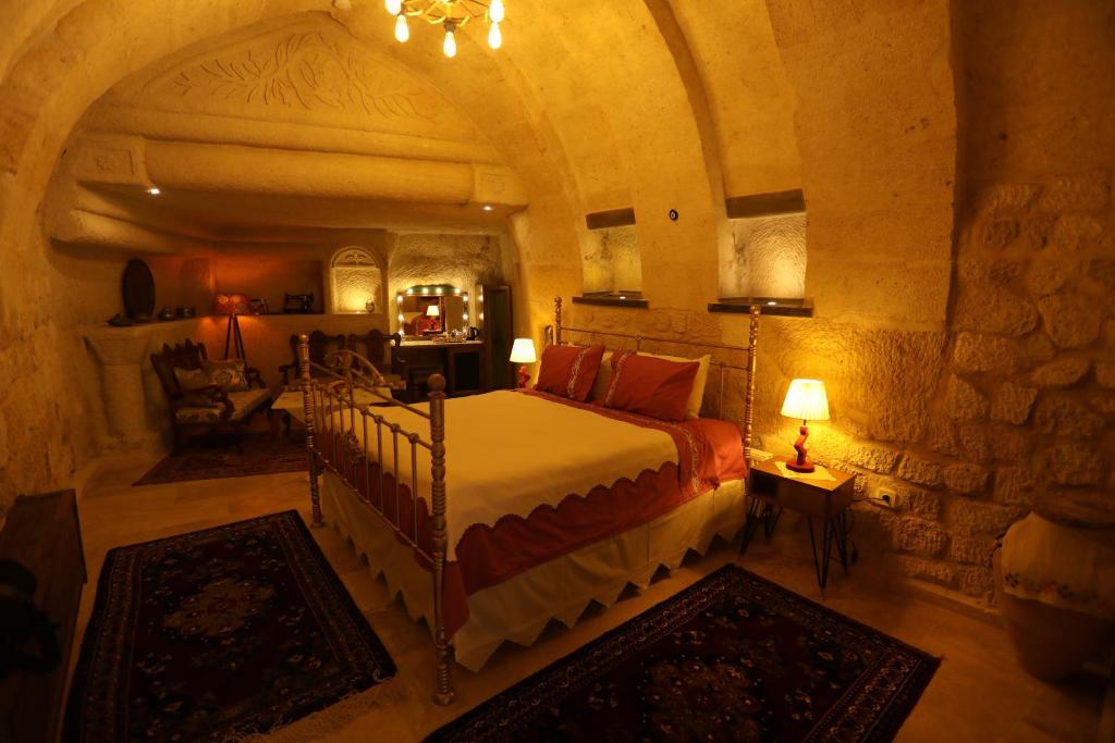于尔居普Hancı Cave Hotel的石头间内一间卧室,配有一张床