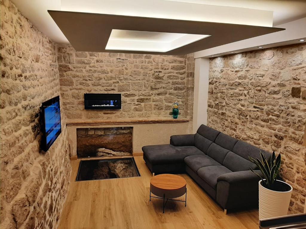 古比奥Appartamento Gattapone 9的带沙发和砖墙的客厅