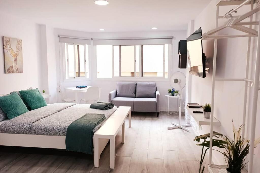 大加那利岛拉斯帕尔马斯Precioso apartamento a 150 metros de la Playa的白色卧室配有床和沙发