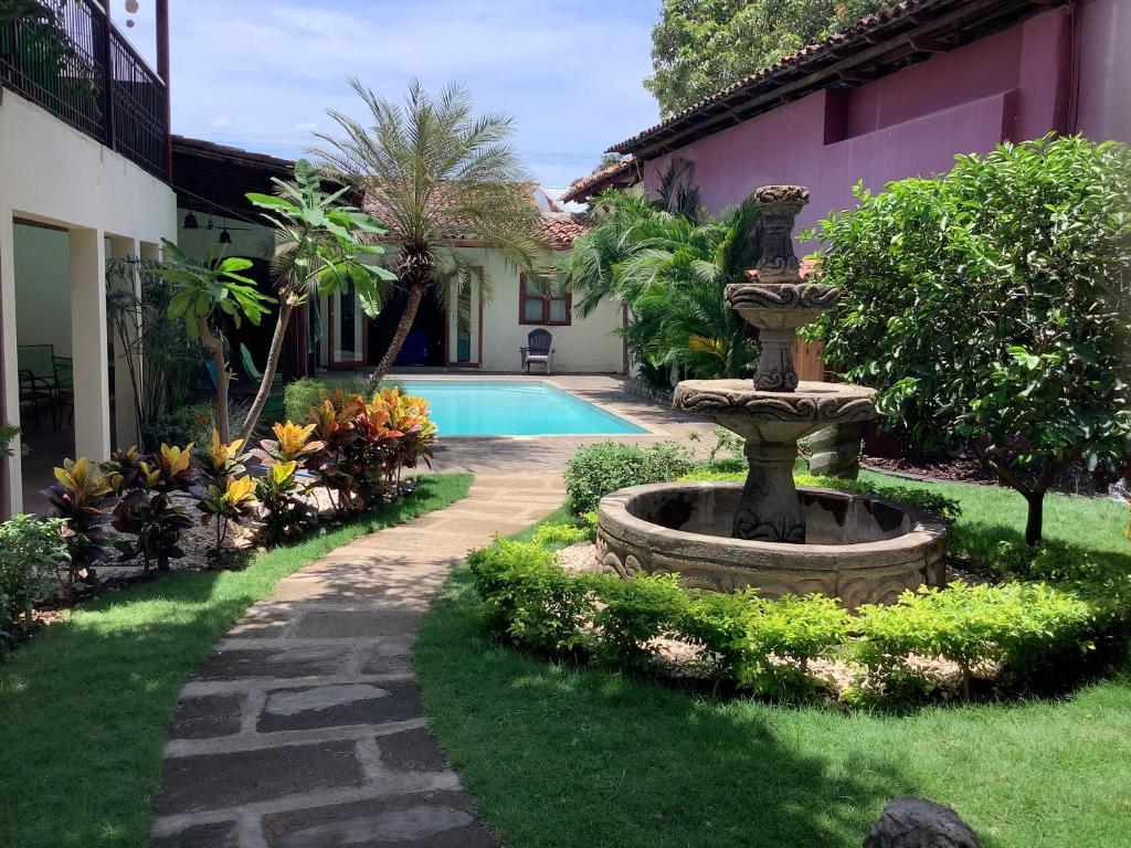 莱昂Casa Riverstone的一座花园,房子前面有一个喷泉