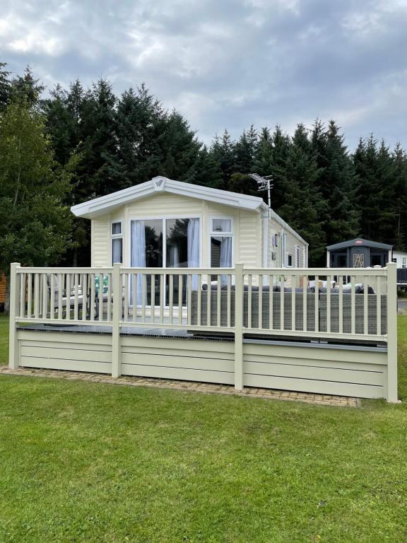 SwarlandLazy Bear Lodge Northumberland的院子中白色围栏的房子