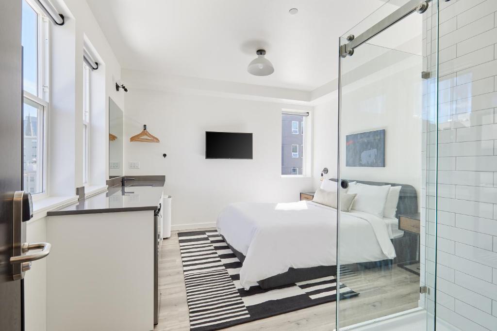 西雅图Sonder The Boylston的白色卧室设有床和玻璃步入式淋浴间