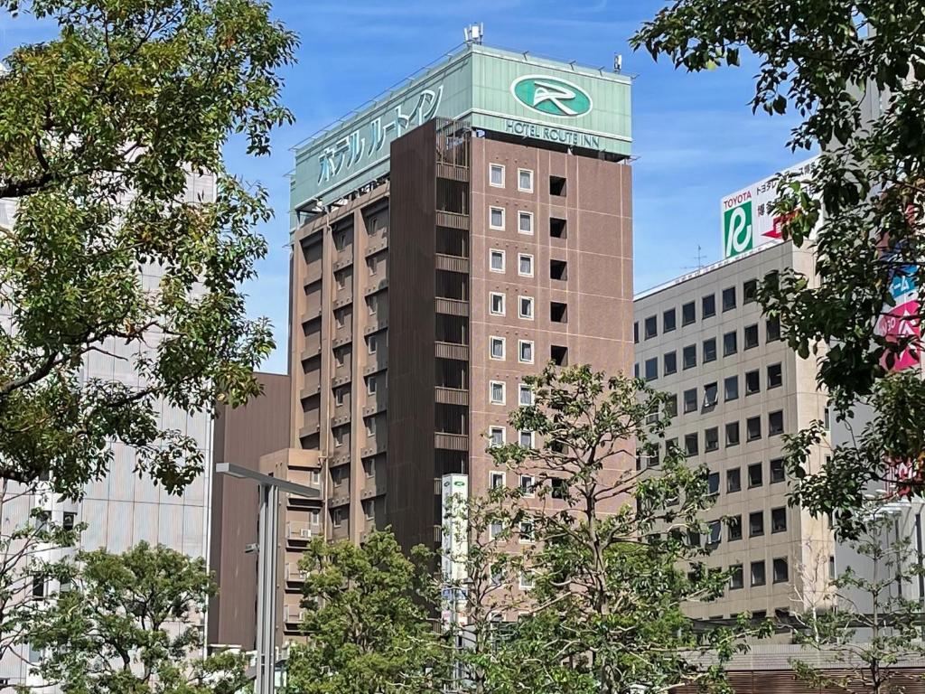 福冈Hotel Route-Inn Hakata Ekimae -Hakataguchi-的一座高大的建筑,上面有标志