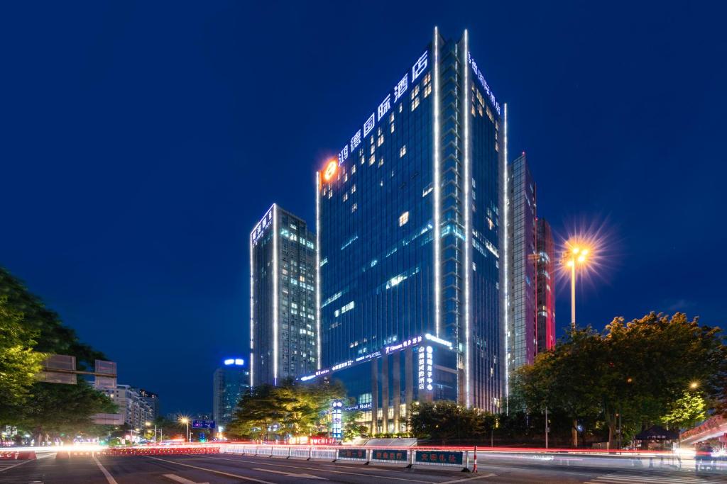 广州鸿德国际酒店的一座高大的建筑,晚上有灯