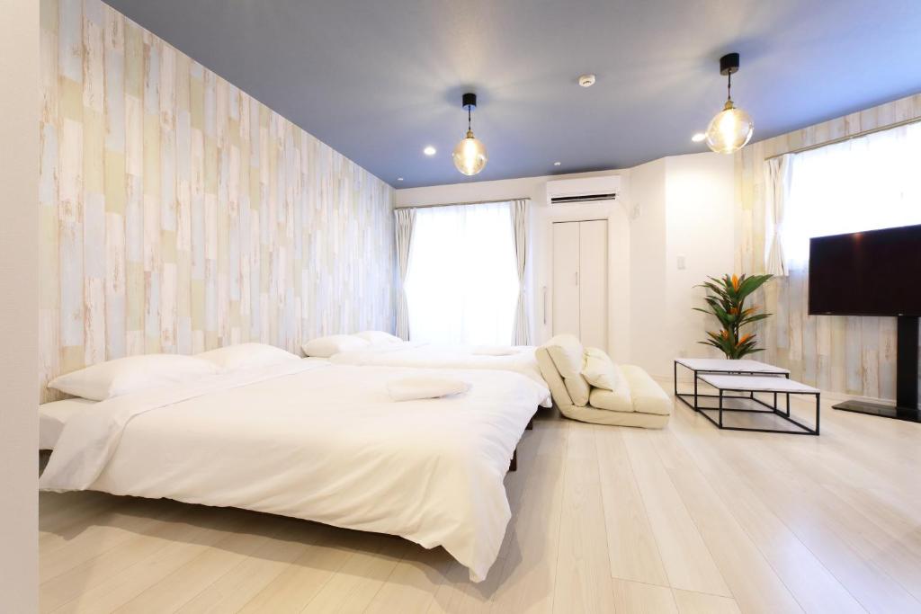 藤泽AQA ART 江の島的一间卧室配有两张床和一台平面电视