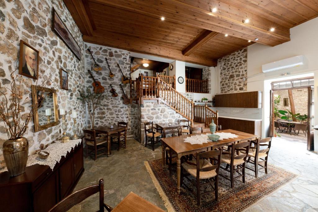纳夫普利翁Rigas Pension Nafplio的一间带桌椅和石墙的用餐室