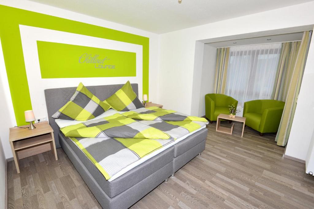 MehlmeiselDas Arni´s的一间卧室配有一张床和两张绿色椅子