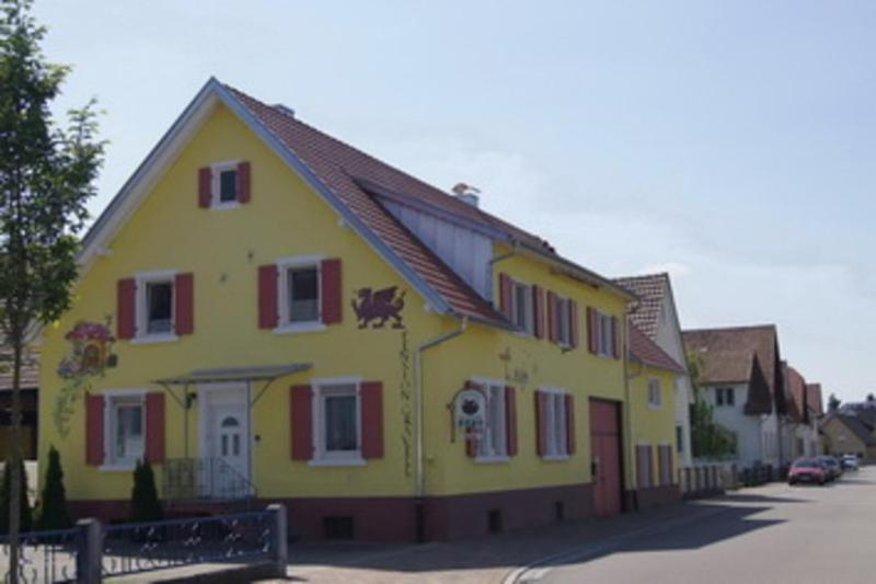 鲁斯特Gaestehaus Gravell的街上有红色百叶窗的黄色房子