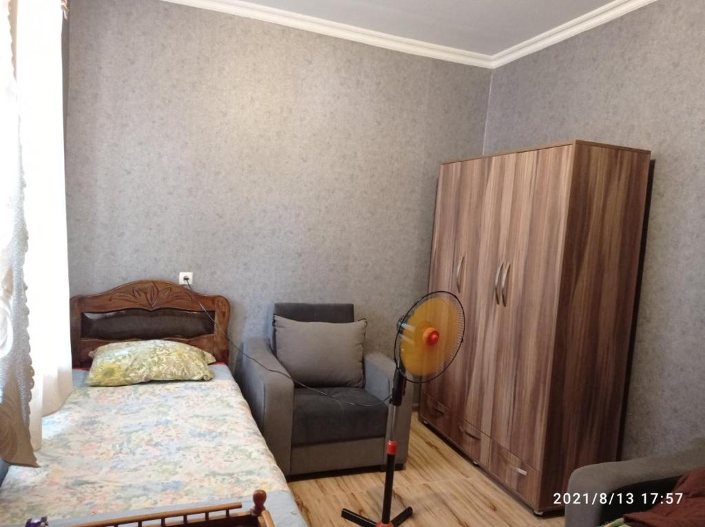 KachretʼiGreen House的一间卧室配有一张床、一把椅子和一个橱柜