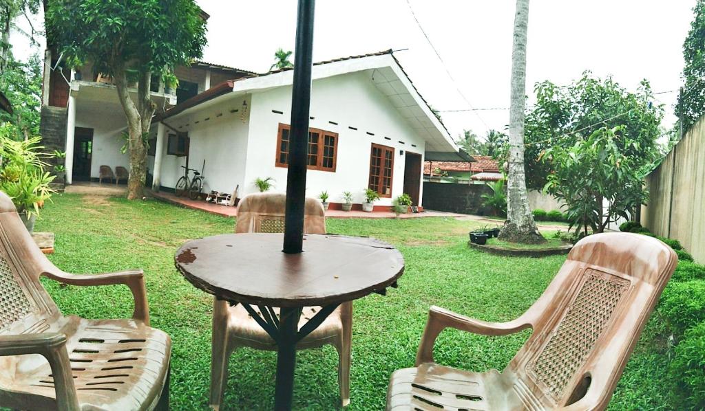 高尔Sanithu Homestay Galle的房子的院子内的桌椅