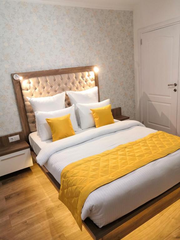 布拉索夫ONYX - Utopia Aparthotel的一间卧室配有一张带黄色枕头的大床