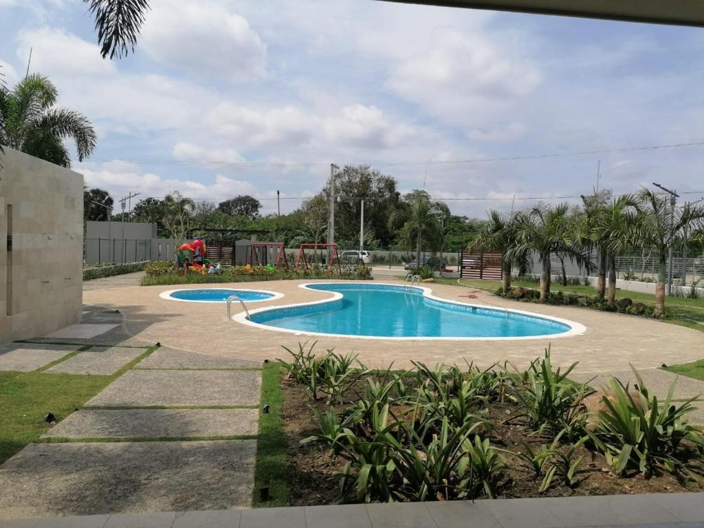 圣地亚哥洛斯卡巴Your Space piscina, parque infantil, 3 habitaciones , Res Breezes Santiago的棕榈树公园内的游泳池