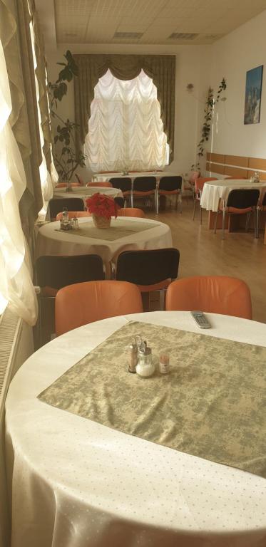 布什泰尼Pensiunea Confort的一间带桌椅的房间和一间带桌椅的房间