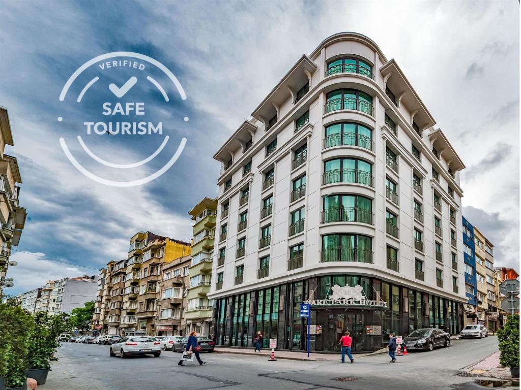 伊斯坦布尔MARE PARK Hotel & SPA的带有安全旅游标志的大型白色建筑的 ⁇ 染