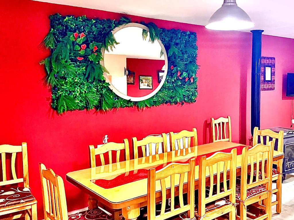 波凯兰特Casa Rural Bekirent的一间设有红色墙壁和桌椅的用餐室