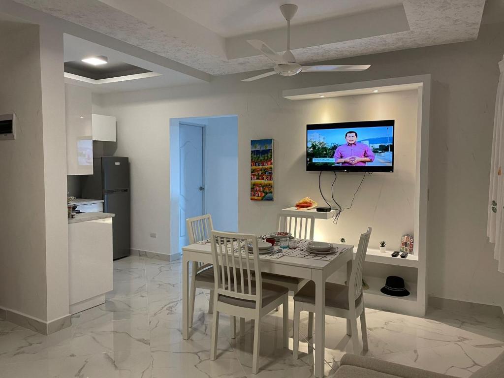 巴亚希贝CASA MARAVILLOSA的一间设有桌子的用餐室和墙上的电视
