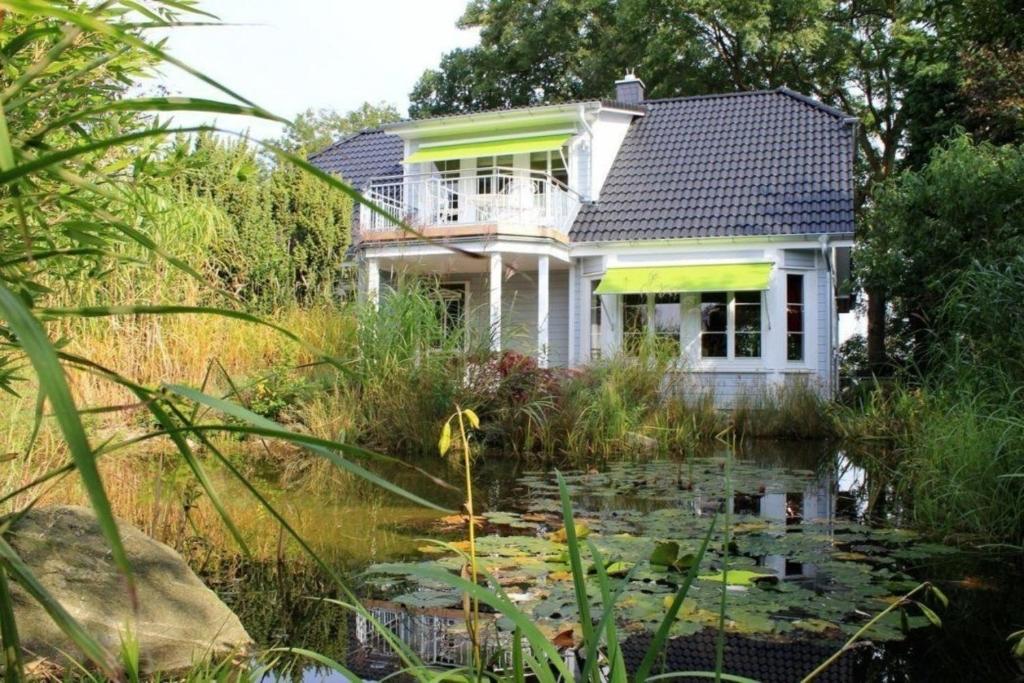 马尔洛Villa Recknitztal Marlow的前面有池塘的房子