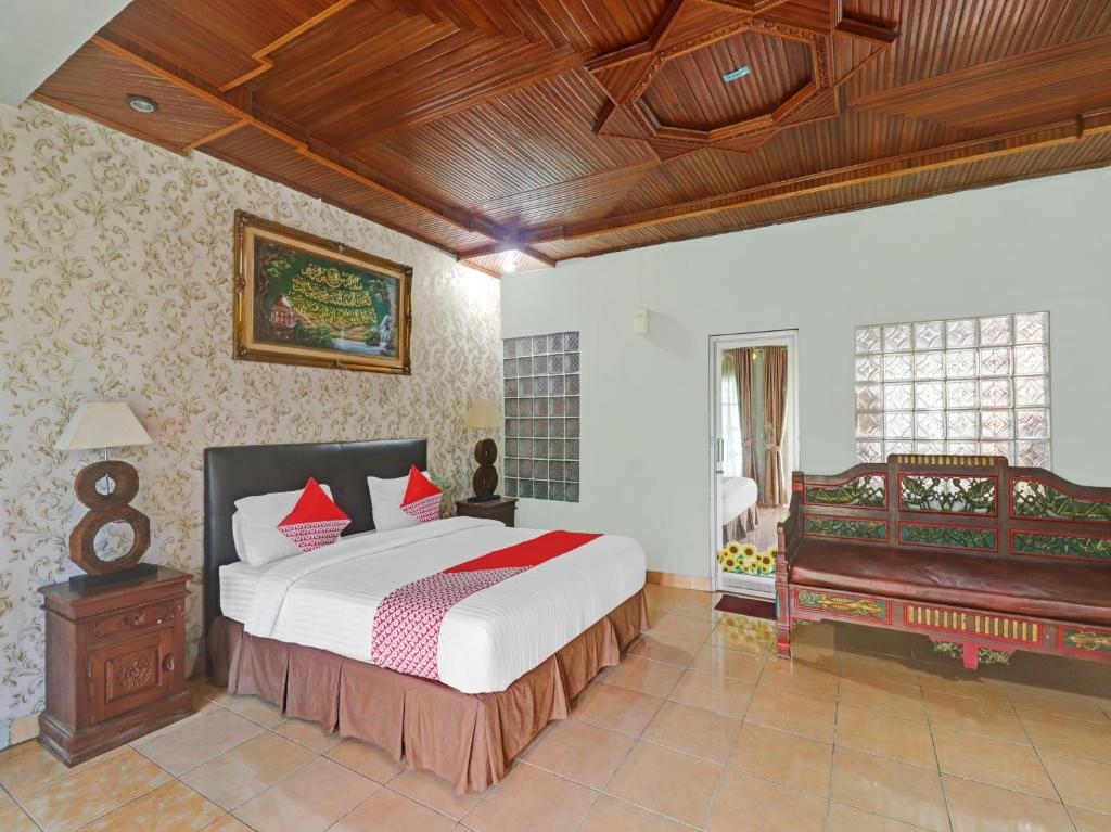 BangkoOYO Life 11350O Hotel R Cantika Syariah的一间卧室配有一张大床和一架钢琴