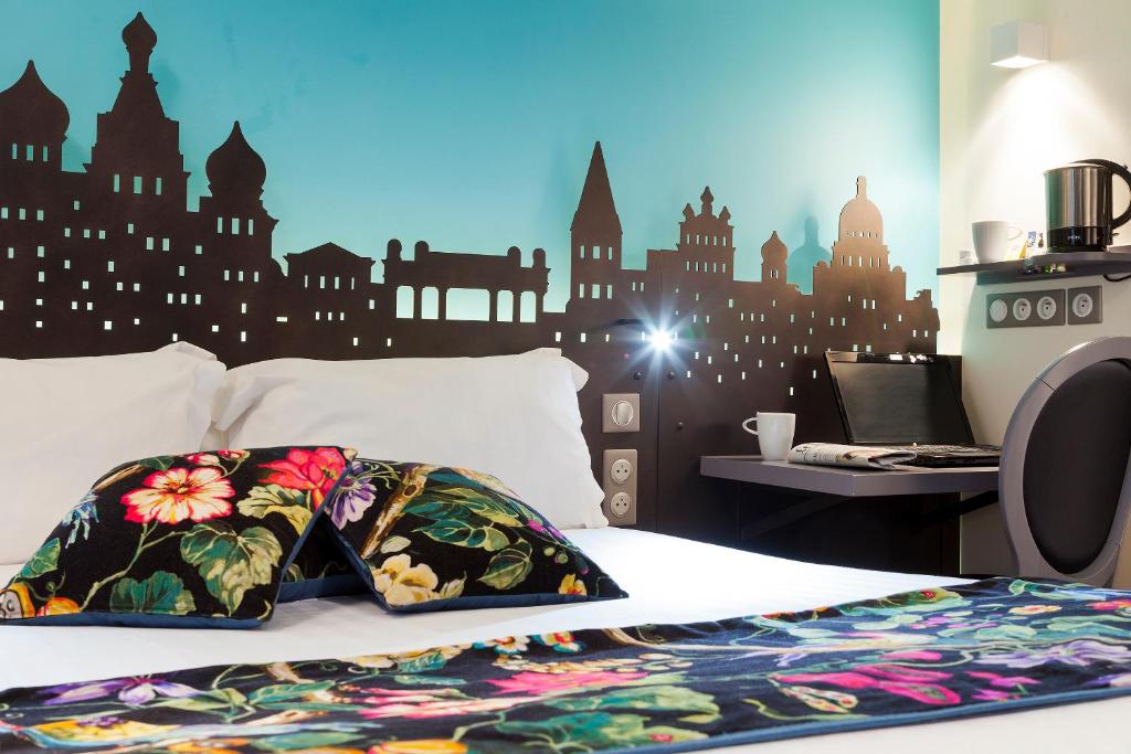 巴黎Hôtel Aurore Paris Gare de Lyon的卧室配有一张挂有城市壁画的床。