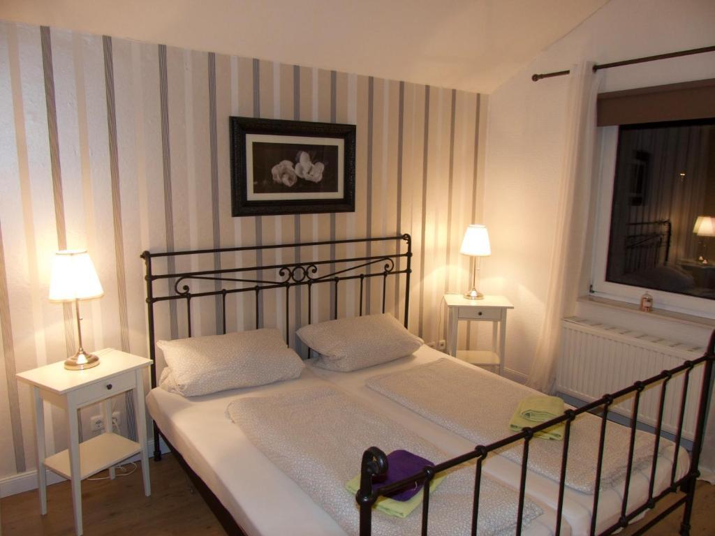 瓦尔斯罗德Ferienhaus Sonnenaufgang的一间卧室配有一张带两张桌子和两盏灯的床。