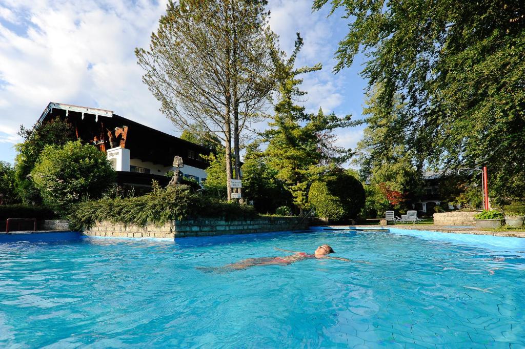 柯尼希斯湖畔舍瑙阿尔皮纳斯托勒酒店的在游泳池游泳的人