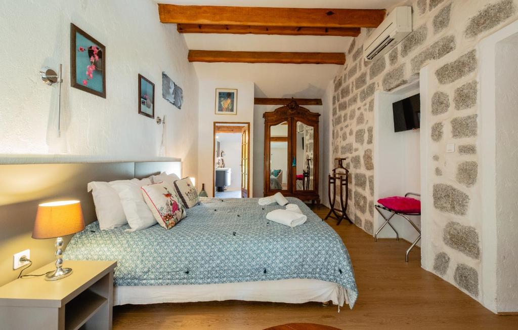 San-Gavino-di-Carbini安簇威尔苏住宿加早餐旅馆的一间卧室设有一张床和石墙