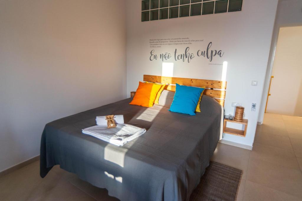 明德卢Amwilla Guesthouse Apartamento Zinha的一张床上有色彩缤纷的枕头