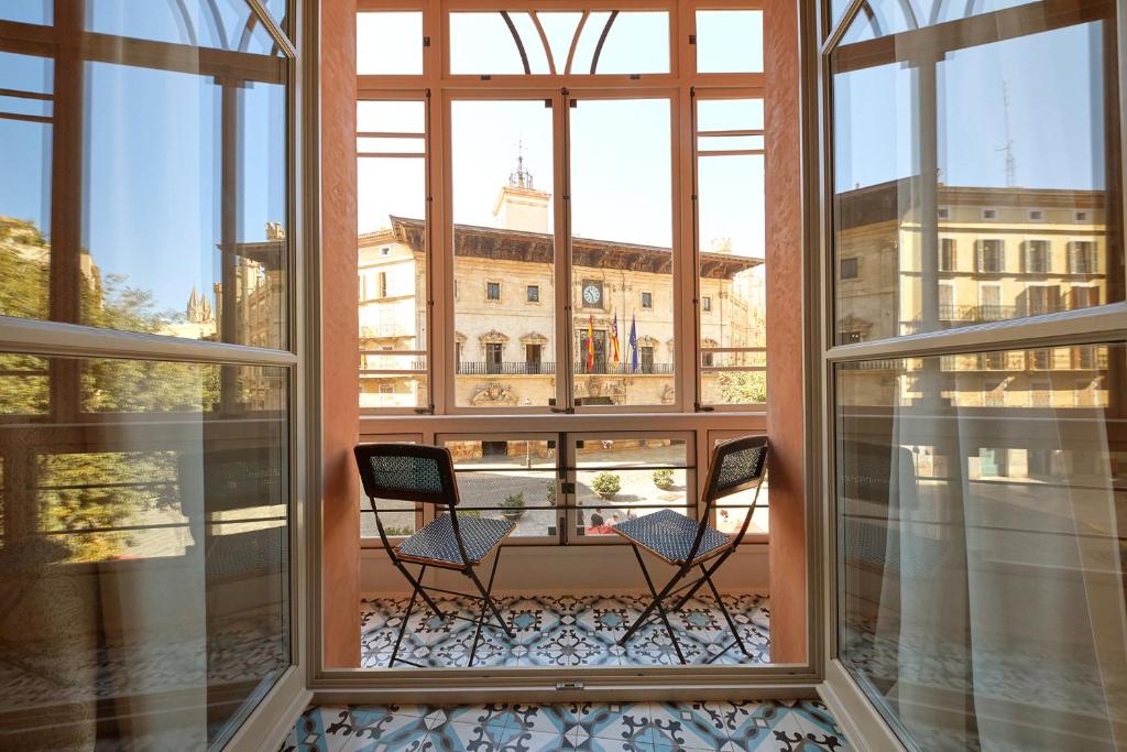 马略卡岛帕尔马Hotel Cappuccino - Palma的阳台设有两把椅子,享有大楼的景色
