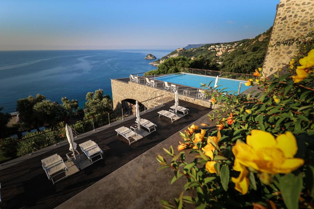 贝尔杰吉Dominio Mare Resort & SPA的享有带椅子的游泳池和大海的景色