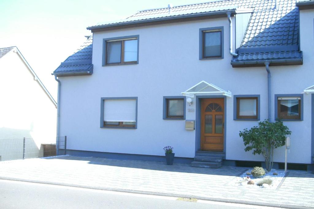 LützkampenFerienhaus Helten的街上的白色房子,有棕色的门
