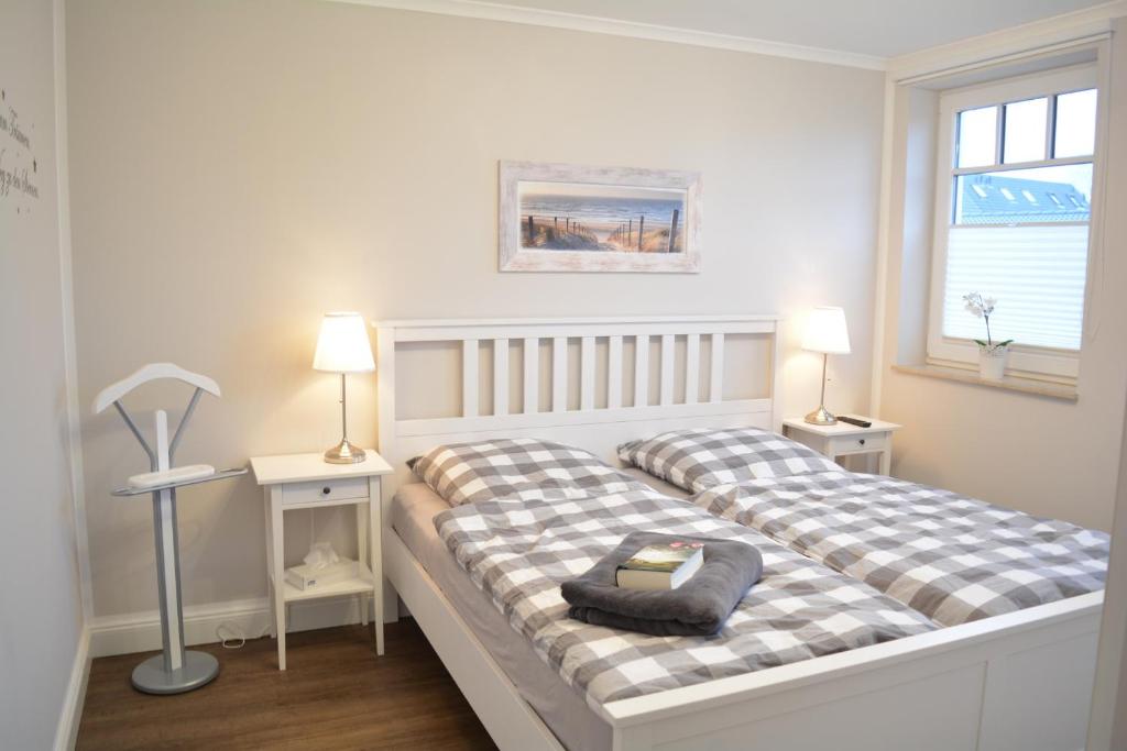 伯尔格伦德-雷特维施Ostwind的白色卧室配有两张床和一盏灯