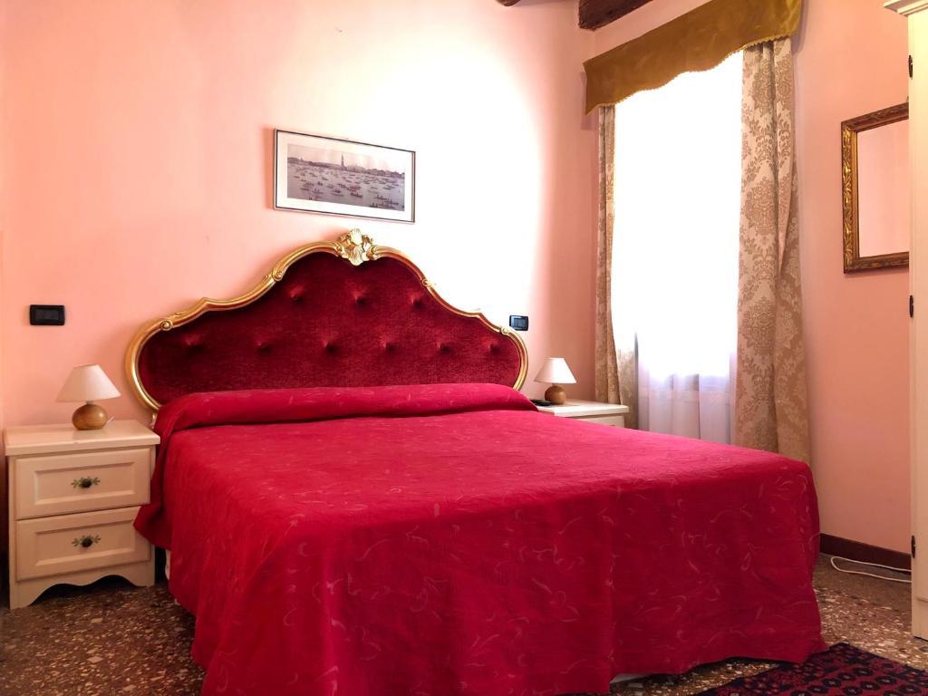 威尼斯阿罗吉塞丽娜酒店的一间卧室配有红色的床罩和红色的床罩