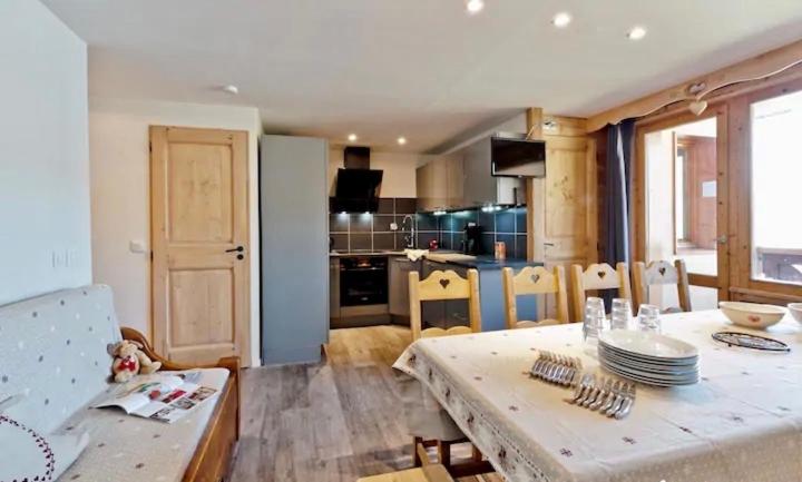 葱仁谷Apartment ski in/out Val Thorens的厨房以及带桌椅的用餐室。
