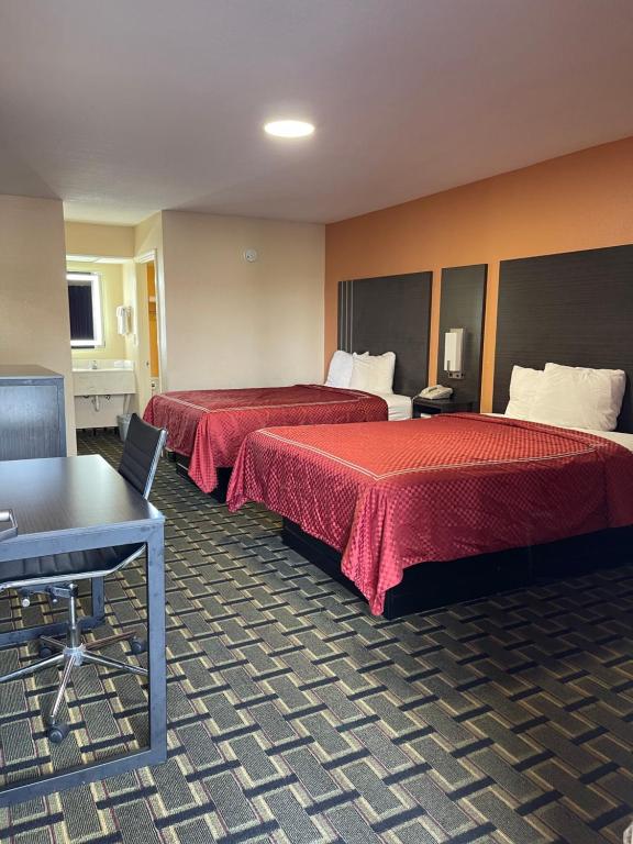 西孟菲斯新罕布什尔州西孟菲斯汽车旅馆的酒店客房设有两张床和一张桌子。