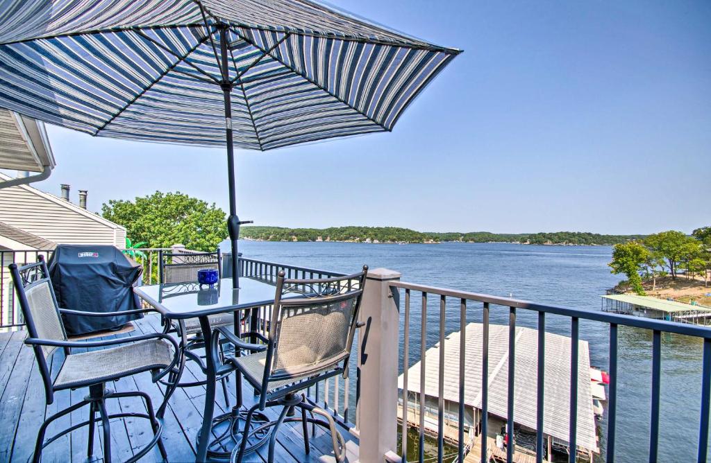 奥沙克湖Waterfront Ozark Gem with Pool Access and Lake Views!的阳台上配有桌椅和遮阳伞