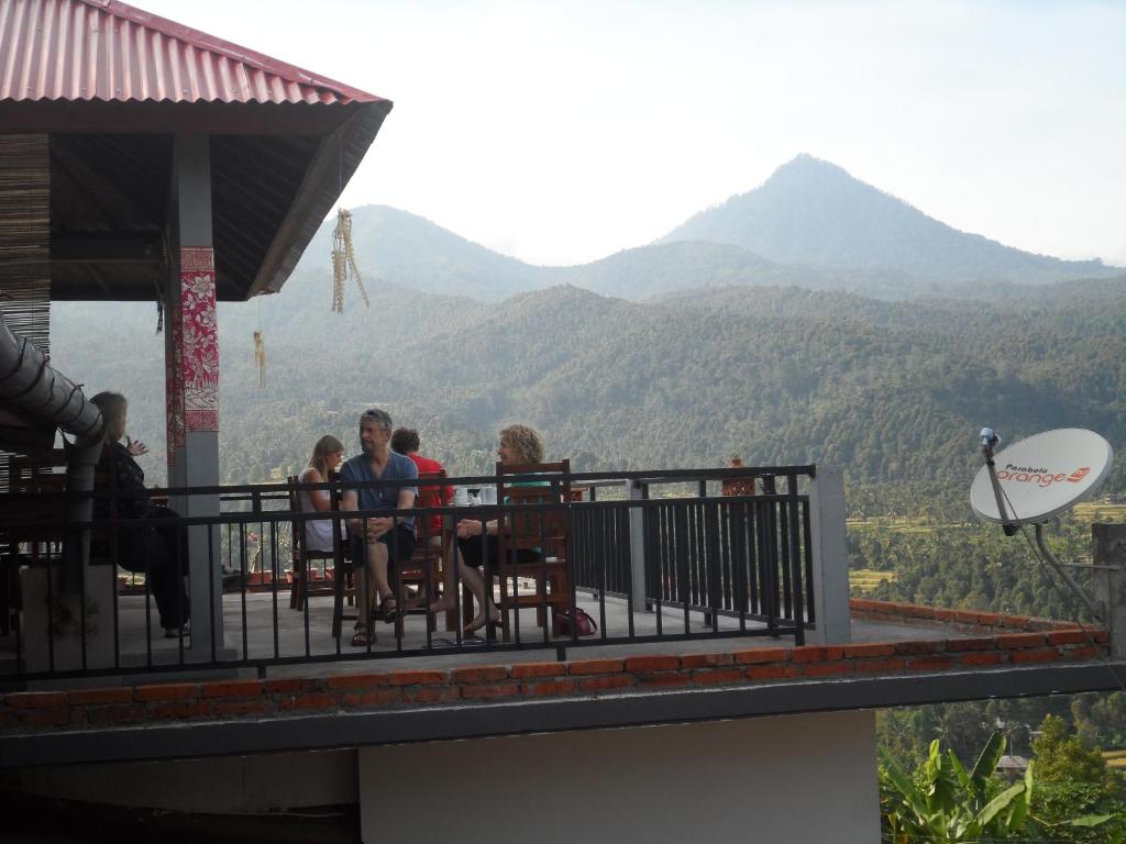 姆杜克瓦伦和一民宿的一群人坐在一个山景阳台上