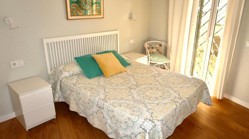 塞维利亚Sevilla Alameda PG Apartamentos的一间卧室配有一张带绿色和黄色枕头的床