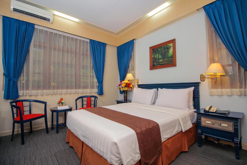 GresikSapta Nawa Resort 1 Gresik的酒店客房带大床和蓝色窗帘