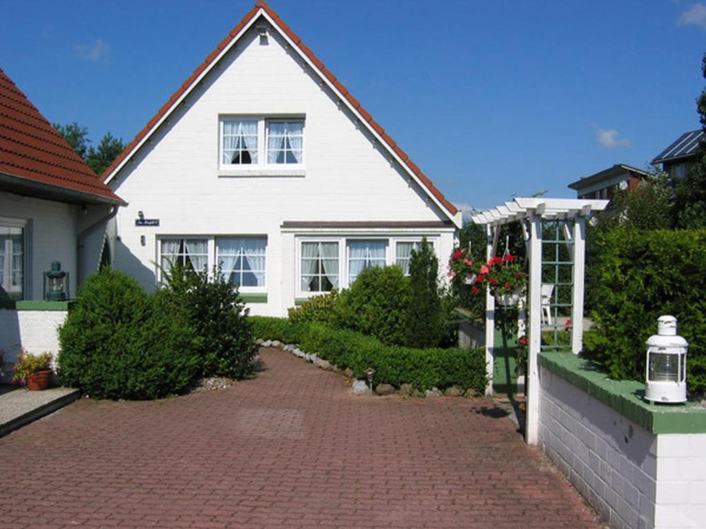 威克奥夫弗尔Am Maisfeld Ferienhaus的砖车道的白色房子