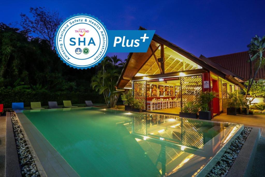 奈汉海滩Naiharn Beach Resort - SHA Plus Extra的一座别墅,在晚上设有游泳池,并标有shka pust标志