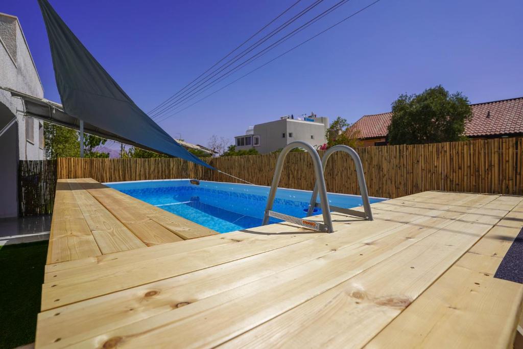 埃拉特YalaRent Green Garden Villa with Private Pool的木甲板,带游泳池的帐篷