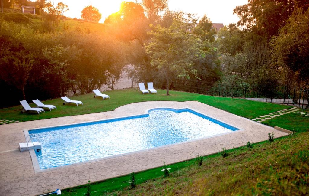 LiañoHotel Peñas Blancas的院子里的游泳池周围设有椅子